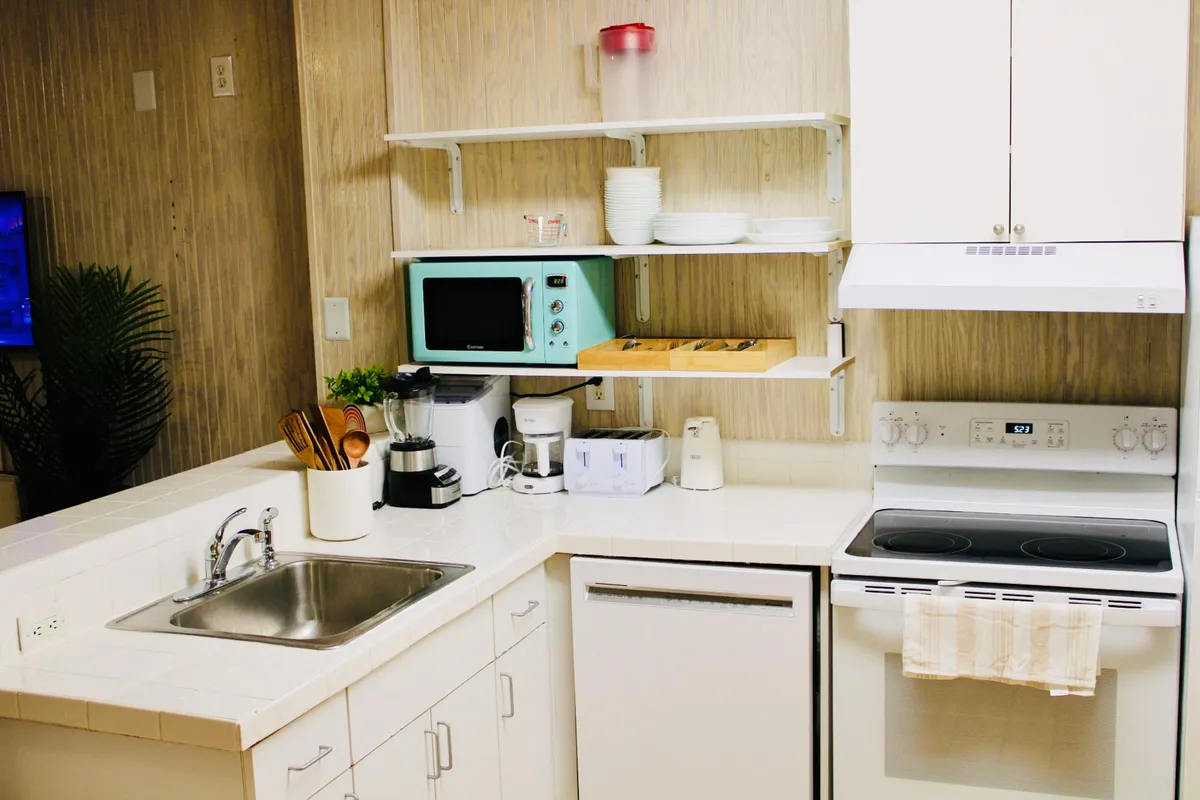 A modern kitchenette interior with a clean sink, microwave, and sleek countertop. The space looks inviting for brewing morning coffee or preparing light meals, with subtle decor touches that enhance the cozy atmosphere.
